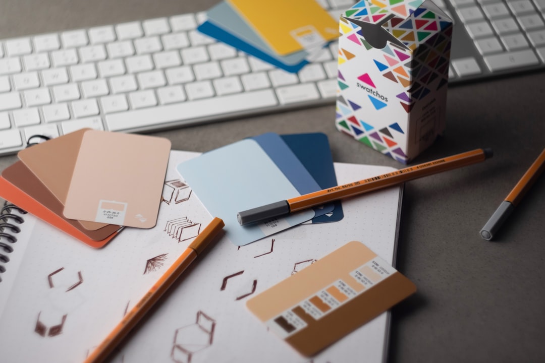 services-04 Swatchos color swatch cards with CMYK and RGB hex values showing being used by a graphic designer on a graphic designers desk