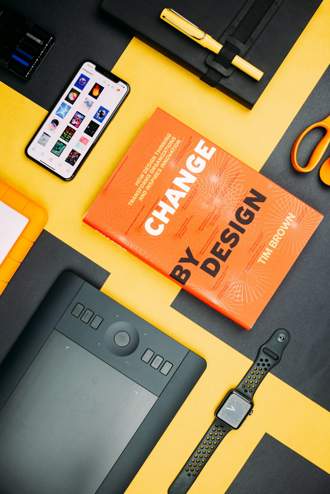 hero-img change-by-design-by-tim-brown-book-beside-smartphone-iyanci0cyrk
